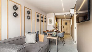 A modern living room with a grey sofa, a dining table with chairs, and decorative vases on the wall. - Kukun Tonalá 121 Roma  (Mexico City)