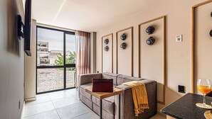 A modern living room with a sofa, a small table, and a glass of wine. - Kukun Tonalá 121 Roma  (Mexico City)