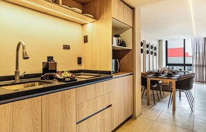 Una cocina moderna con armarios de madera, un lavamanos de acero inoxidable y un horno empotrado.