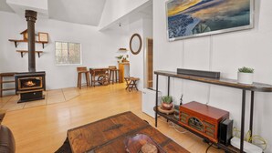 A living room with a fireplace, wooden furniture, a painting, and a television.