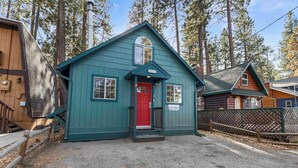 A small, single-story building with a red door and a mailbox.