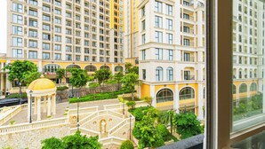 A high-rise building with multiple balconies and a central courtyard with a fountain. - Hub Multi Hotel Phu Quoc (Phu Quoc)