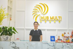 A reception desk with a marble top, a potted plant, and a 'Hub Multi' sign on the wall. - Hub Multi Hotel Phu Quoc (Phu Quoc)