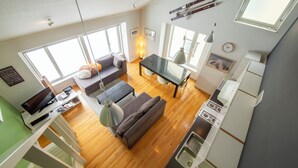 A modern apartment with a living room, dining area, kitchen, and a balcony. - First Tracks (Kutchan)