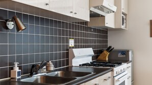 A modern kitchen with a stainless steel sink, a gas stove, and wooden cabinets. - First Tracks (Kutchan)