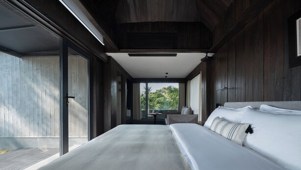 Une chambre d’hôtel moderne avec un grand lit, une petite table et une vue sur l’extérieur.