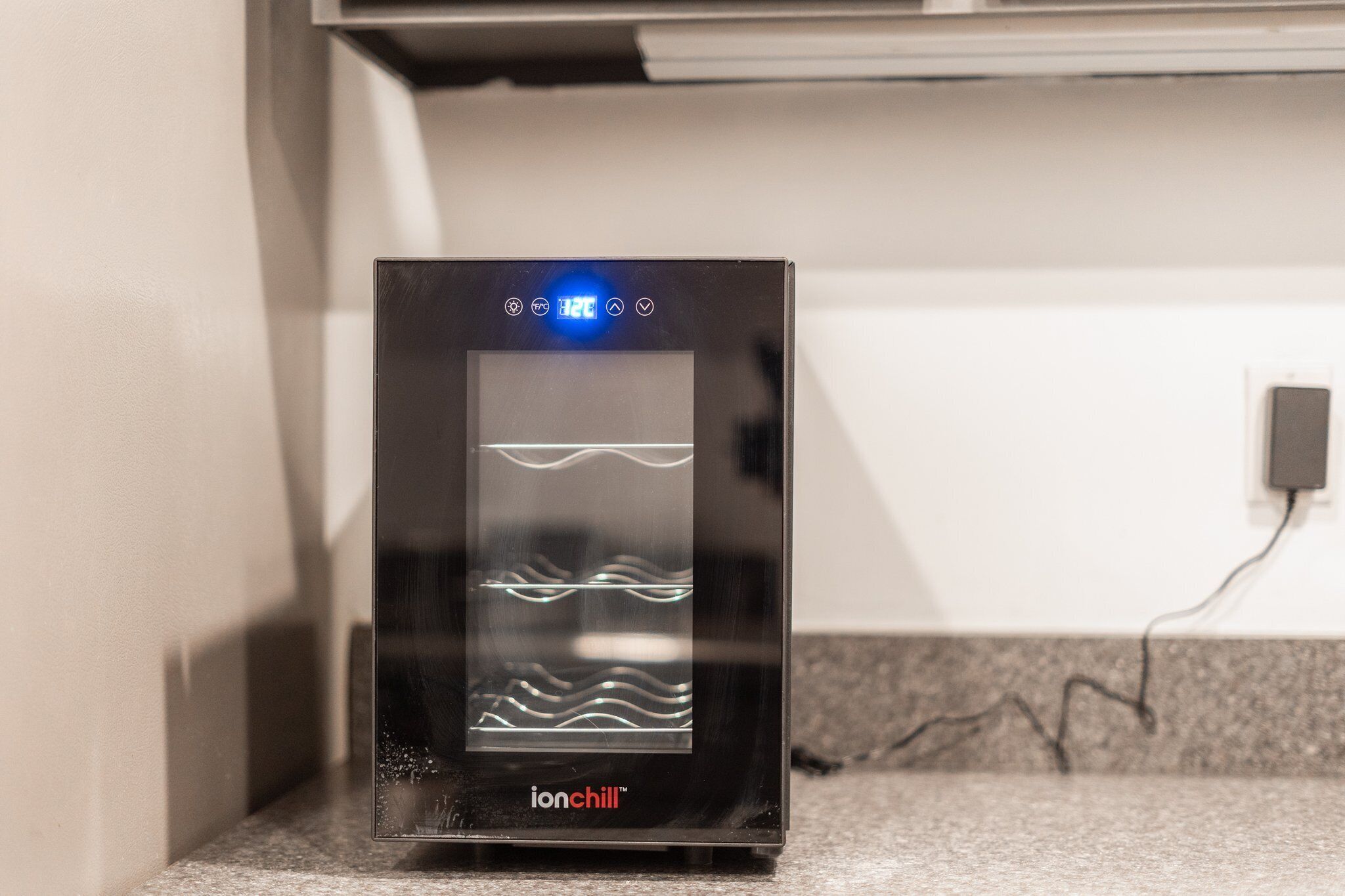 A black ionchill refrigerator with a digital display, located on a countertop.