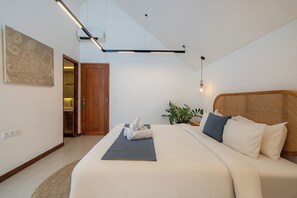 Une chambre d’hôtel moderne avec un grand lit, une plante sur la table de chevet et une tête de lit en bois.