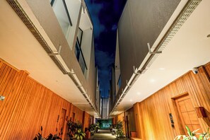Ein schmaler Korridor mit Holzvertäfelung an beiden Seiten, einer Decke mit Sternenhimmel-Design und einem Schild mit der Nummer 5 an der rechten Wand.