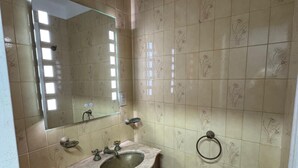 Ein Badezimmer mit Waschbecken, Spiegel und Toilette.