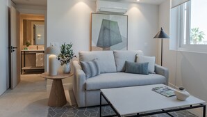 Una sala moderna con sofá, mesa de centro y una mesita auxiliar con un florero.