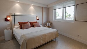 Un dormitorio con una cama grande, lámparas de noche, una ventana con vistas y una obra de arte en la pared.