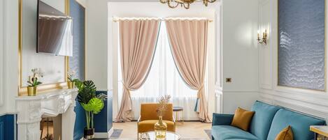 Ein Wohnzimmer mit einem blauen Sofa, einem goldenen Couchtisch und einem Kamin.
