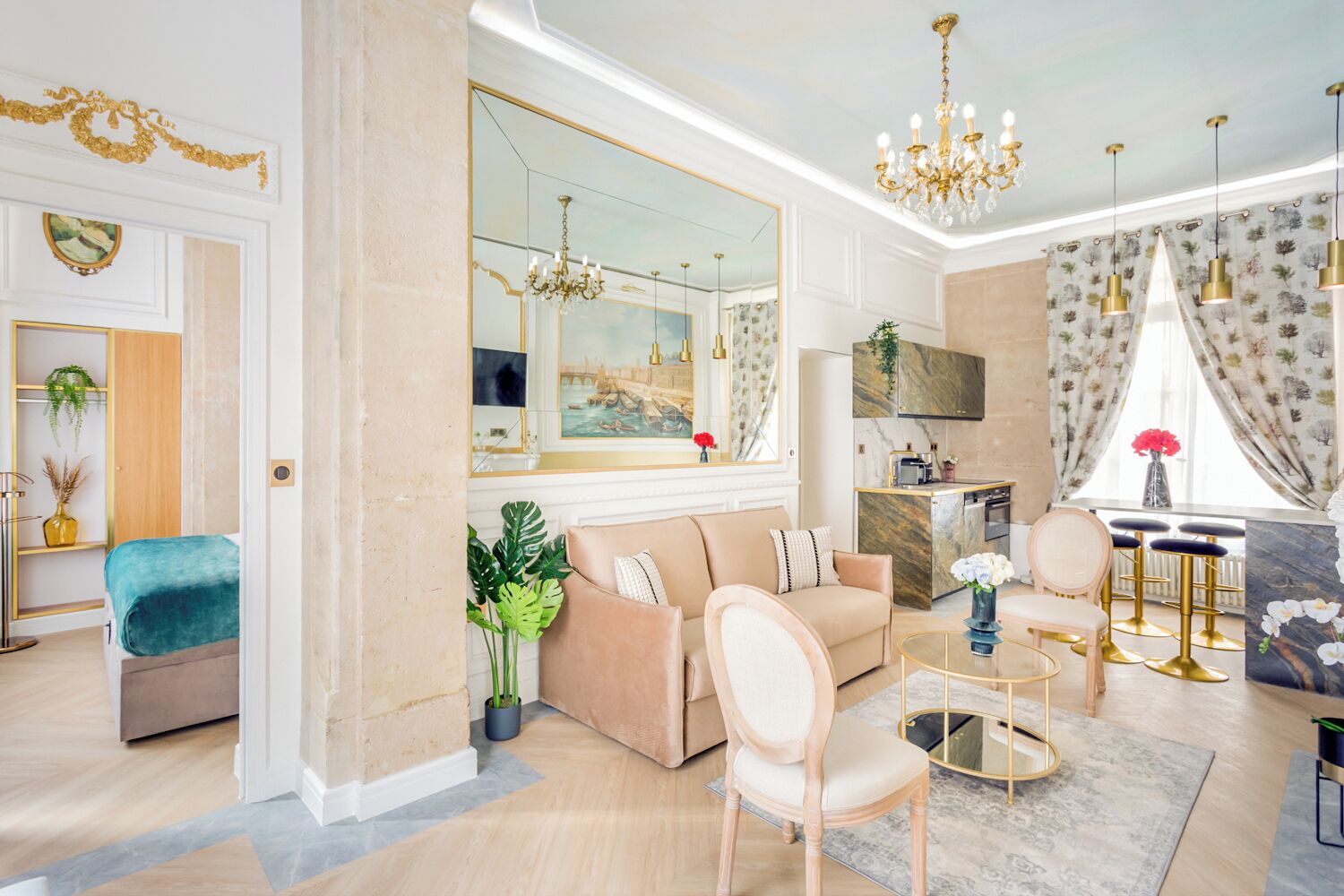 A spacious living room with a large mirror, a sofa, a coffee table, and a dining area with bar stools.