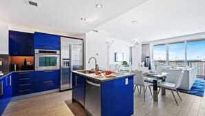 Una cocina moderna con armarios azules, horno integrado y refrigerador.