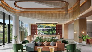 A spacious lobby with a central seating area, large windows, and a mural on the back wall.