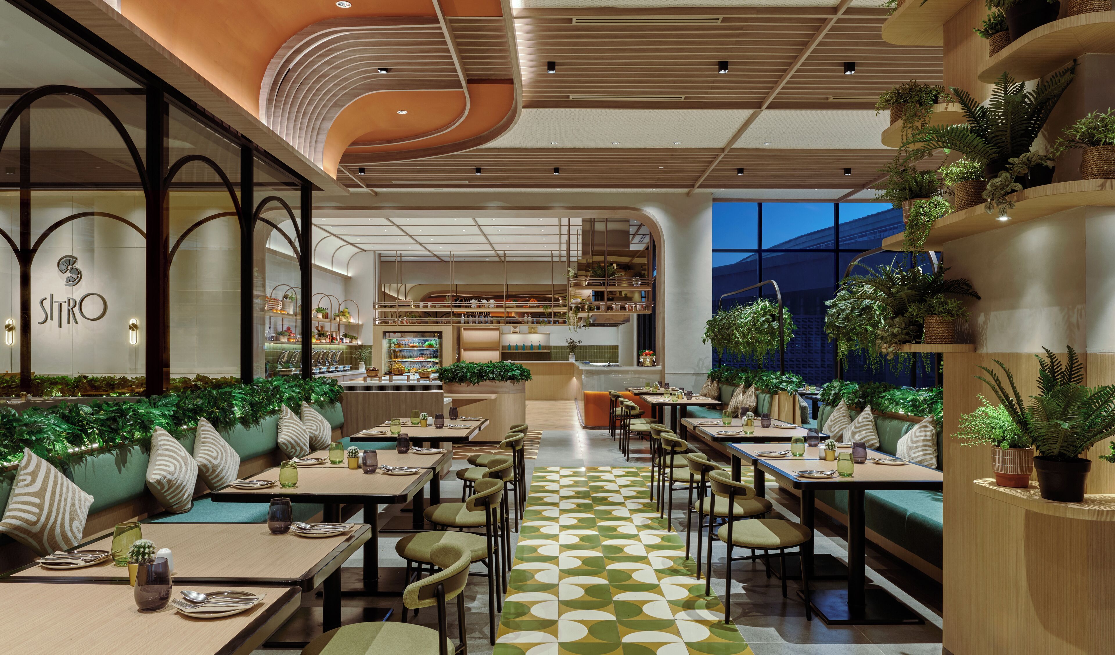 A modern restaurant interior with a central dining area, booths, and a kitchen in the background.