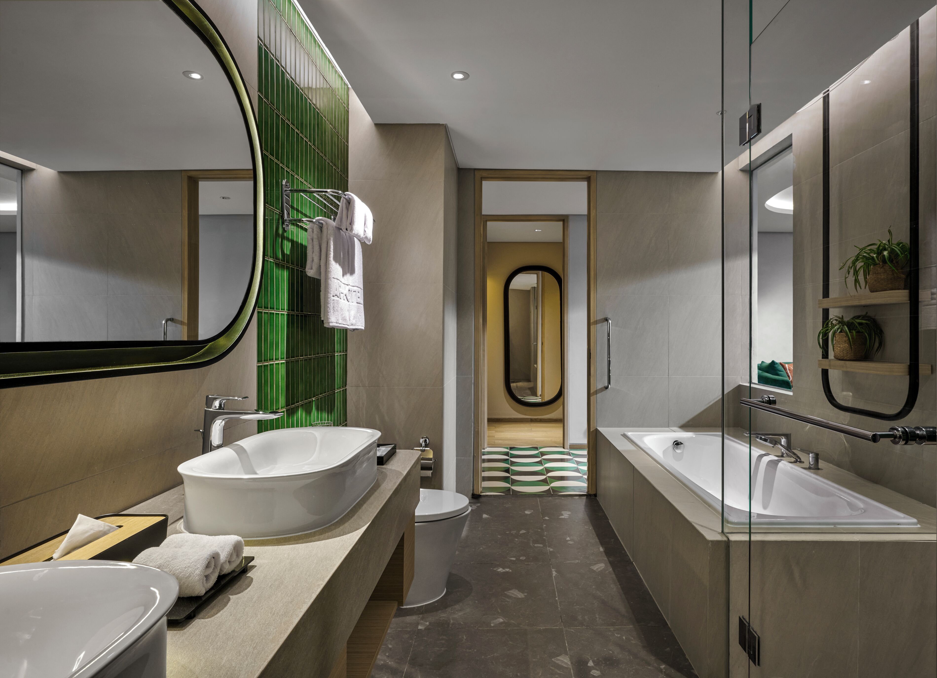 A modern bathroom with a large bathtub, a separate shower area, and a vanity with a large mirror.