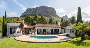Une villa dotée d’une piscine, d’un espace extérieur aménagé et offrant une vue sur les montagnes.