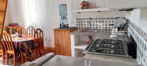 Utensilis de cuina, vaixella i coberteria i una taula de menjador