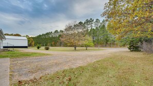 A gravel driveway leading to a white building with a black railing. - Fisher's Retreat: Hayward Home, Near ATV Trails! (Hayward)