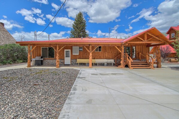 A wooden cabin with a red roof, a stone fireplace, and a covered porch. - Group Getaway w/ Mtn Views: Home in Circleville! (Circleville)