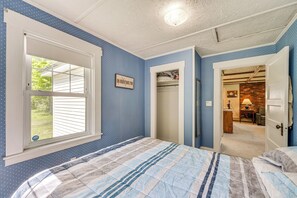 Ein Schlafzimmer mit einem Bett, einem Fenster und einer Tür zu einem Badezimmer.
