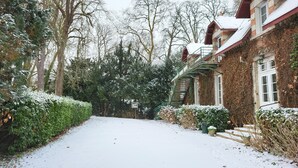 A snow-covered pathway leading to a brick house with a green staircase. - Gîte du Château - 18 people - Centre de la France - au coeur du Berry (Cluis)
