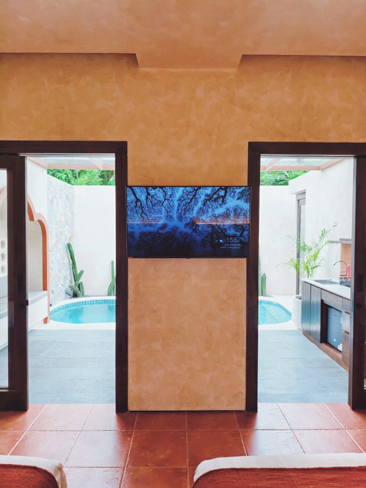 A room with a large window overlooking a swimming pool and outdoor area.