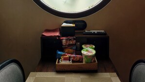 Ein runder Spiegel mit Blick auf eine Palme, ein Tablett mit Snacks und ein Rauchverbot-Schild.