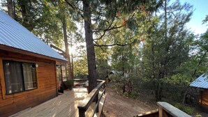 Une cabane en bois dotée d’une terrasse et d’un escalier menant à un espace abrité.