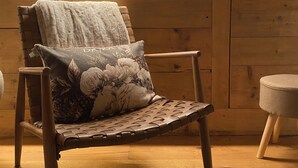 A wooden chair with a floral cushion in a room with wooden walls and a wooden floor. - Cozy apartment with panoramic views of the Casies Valley (Trentino-Alto Adige)