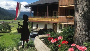 A wooden chalet with balconies, surrounded by greenery and flowers. - Cozy apartment with panoramic views of the Casies Valley (Trentino-Alto Adige)
