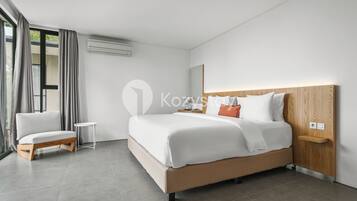 A modern hotel room with a large bed, a small bedside table, a chair, and a large window with curtains.