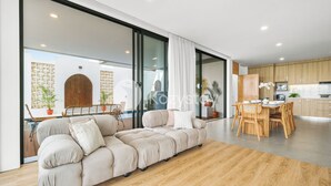 A modern living room with a large sofa, a dining area with wooden furniture, and a kitchen with wooden cabinets. - Sorte by Kozystay - Dago (Cimenyan)