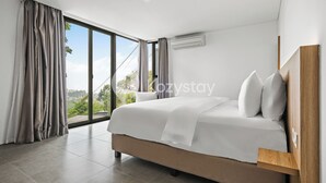 A modern hotel room with a large bed, a wooden headboard, and a view through a sliding glass door. - Sorte by Kozystay - Dago (Cimenyan)