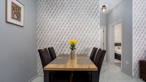 A dining area with a wooden table, black chairs, and a vase with yellow flowers. - Apartment Estate 2 - Island Krk by Villas Guide (Malinska)
