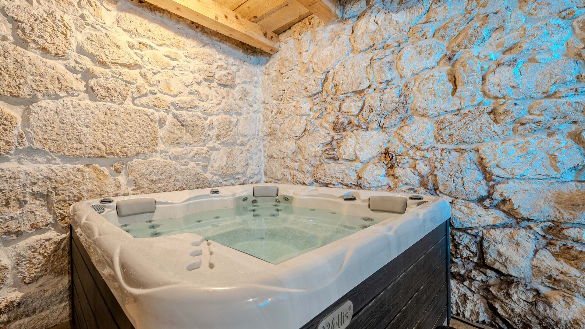 A stone-walled bathroom with a hot tub.