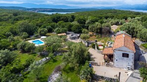 A villa with a swimming pool, stone ruins, and a view of the surrounding forest and mountains. - Villa Verde Oliva Residence by Villas Guide (Dobrinj)