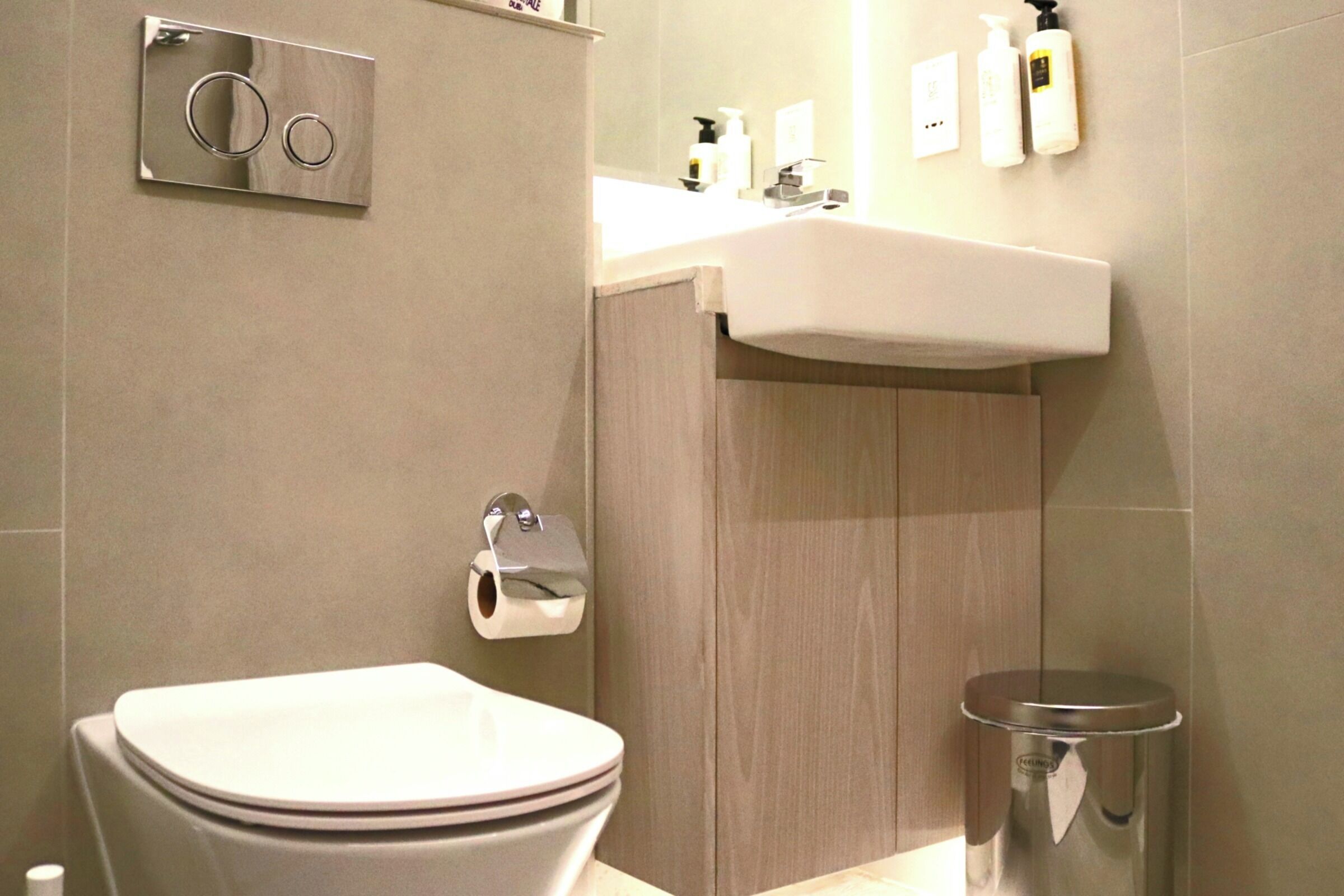 Une salle de bain moderne équipée de toilettes, d’un lavabo et d’une poubelle.