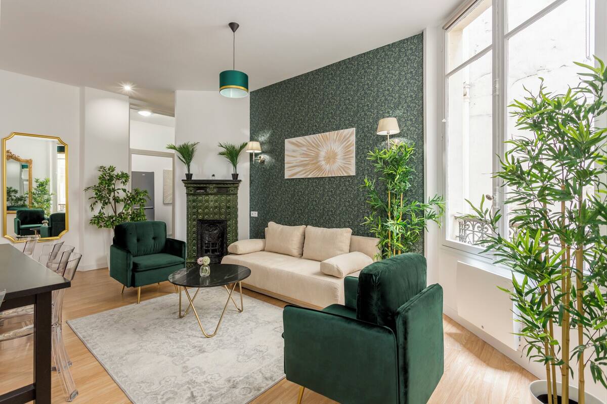 Uma sala de estar moderna com um sofá verde, lareira e uma janela ampla.