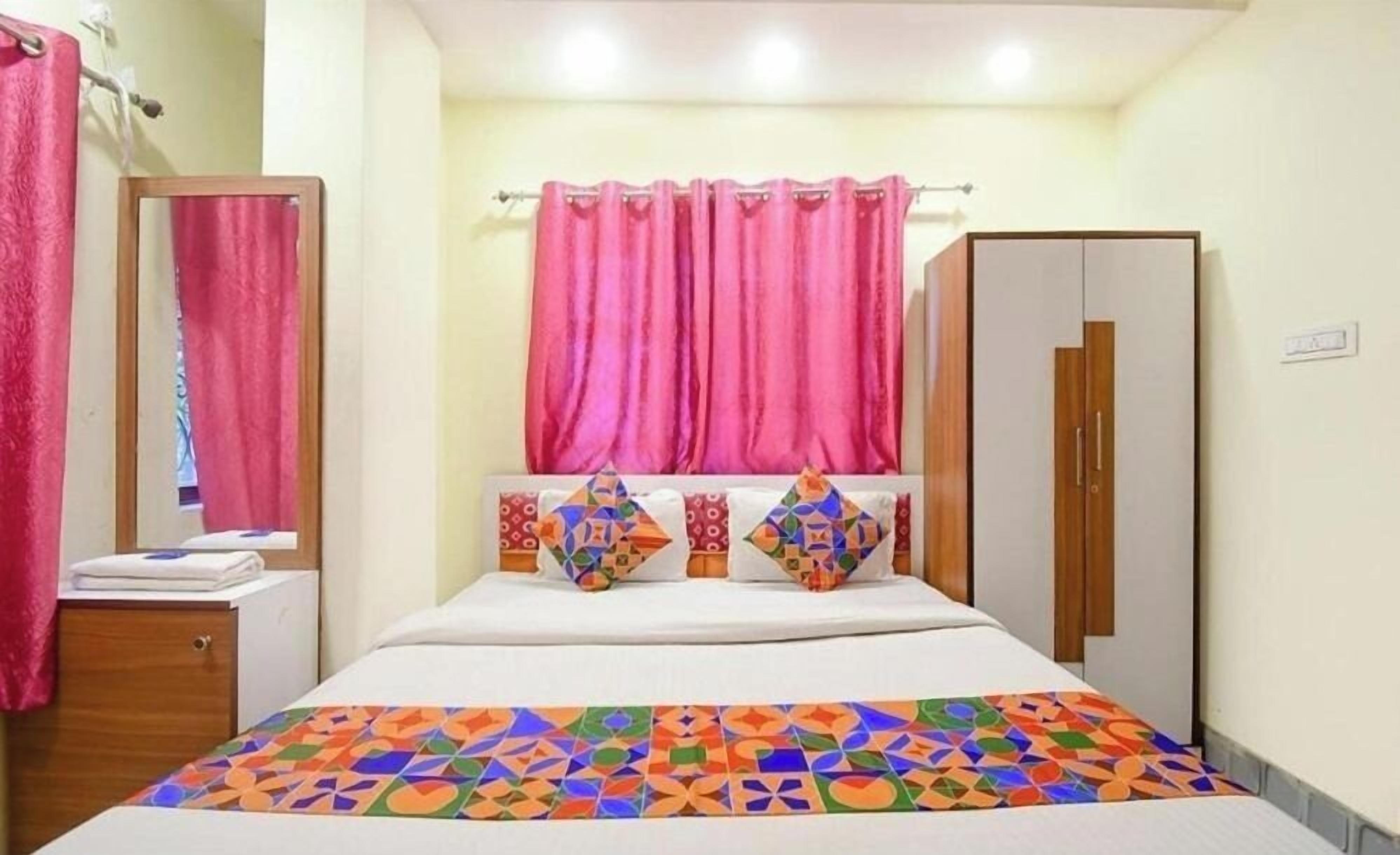 A bedroom with a bed, a wardrobe, and a mirror.