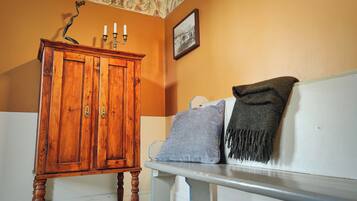A room with a wooden cabinet, a bench, and a wall with a decorative panel.