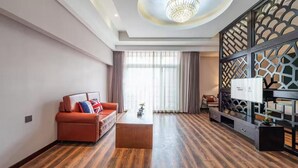 A modern living room with a sofa, coffee table, and decorative wall paneling. - Le Peng hotel (Tianjin)