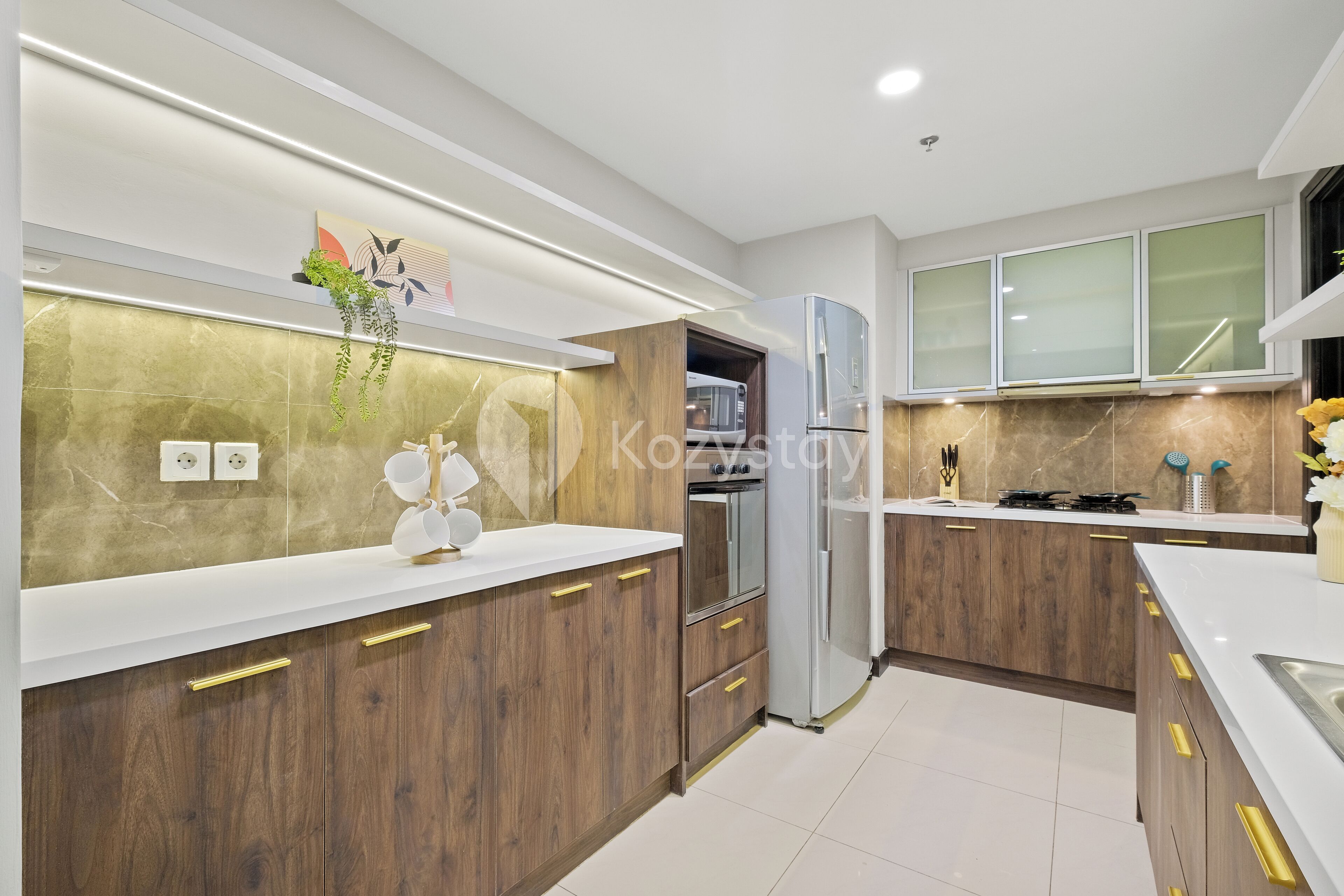 Una cocina moderna con armarios de madera, electrodomésticos de acero inoxidable y una encimera blanca.