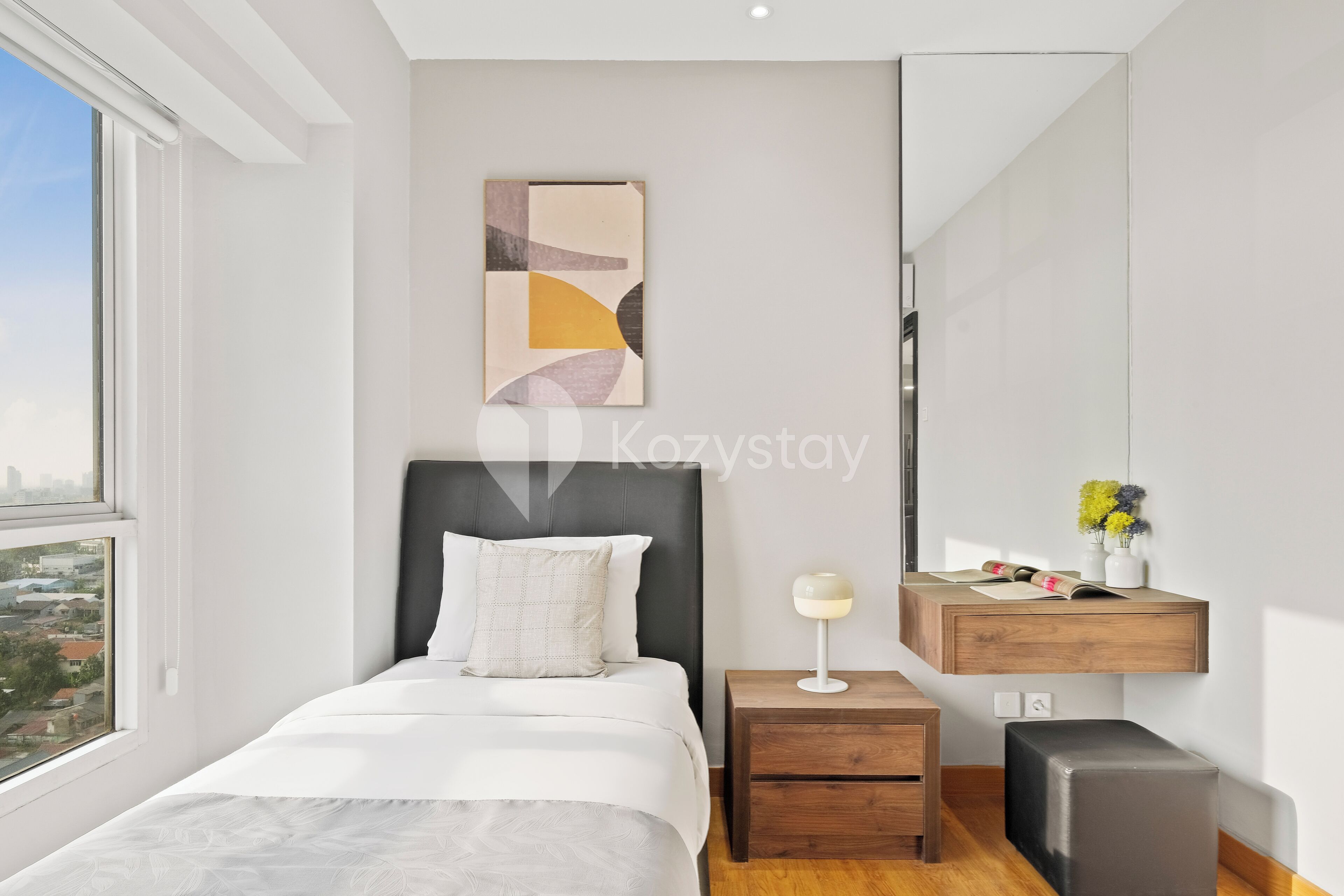 Ein modernes Schlafzimmer mit Bett, Nachttisch und Blick auf die Stadt.