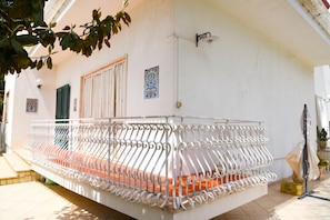 A balcony with a white metal railing, a door, and a wall-mounted light fixture. - Dimora San Pancrazio (San Pancrazio Salentino)