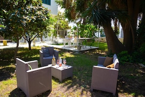 An outdoor seating area with wicker furniture, a table, and a potted plant. - Dimora San Pancrazio (San Pancrazio Salentino)