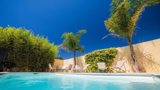 A swimming pool with lounge chairs and palm trees. - CosyFamily 1st floor-Pool-Wifi-Family-Plage (Pérols)