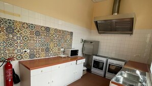 A kitchen with white cabinets, a microwave, a stove, and a sink. - Group gîte, many activities, river, footbridge, dogs ok, nature (Mazamet)